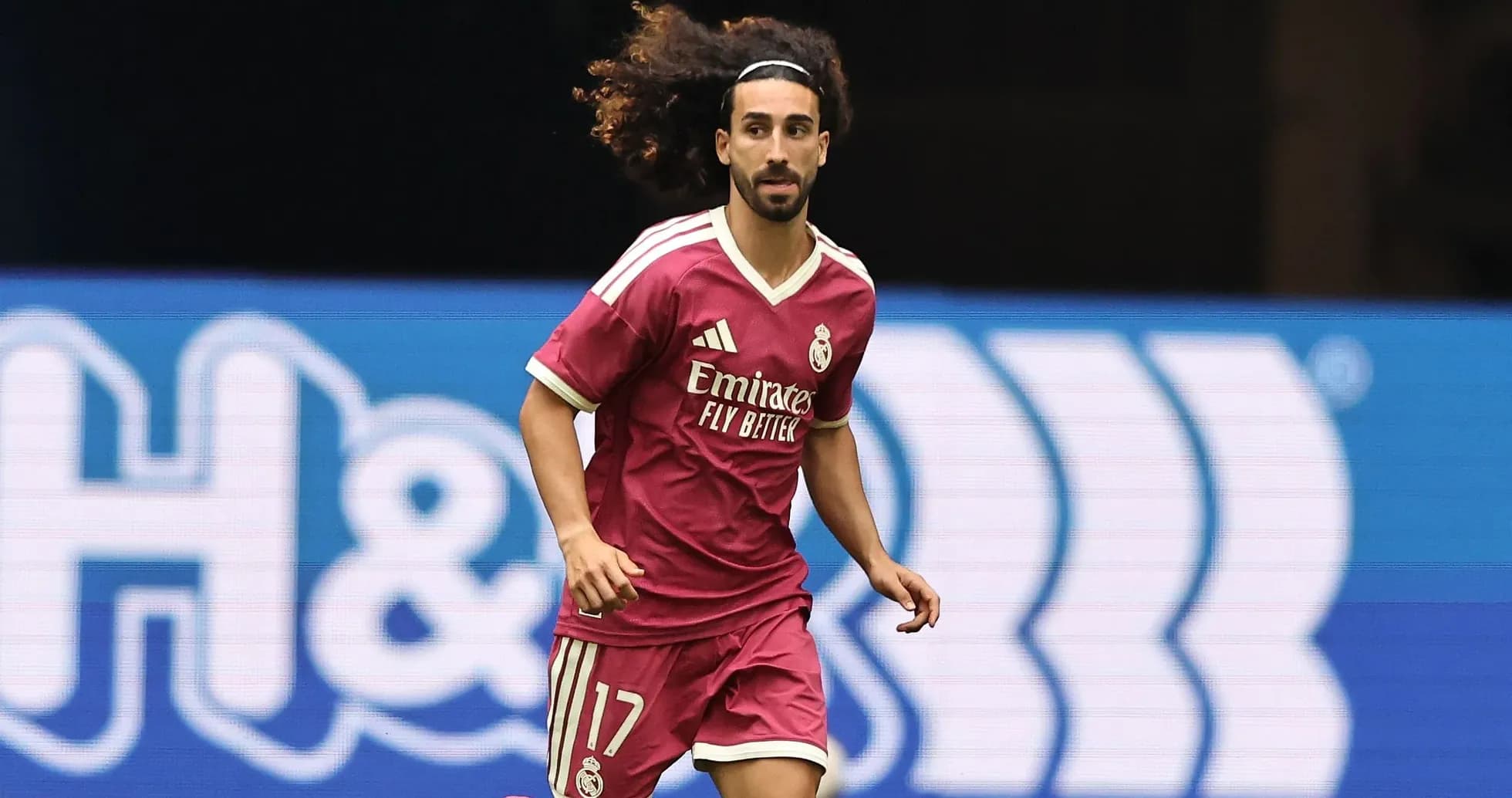 Player running in pink Real Madrid jersey on field