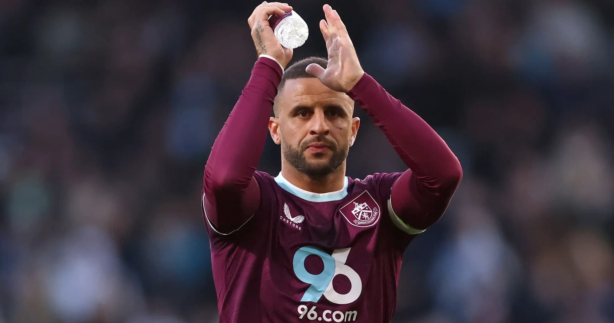 Player applauding fans while holding a bottle