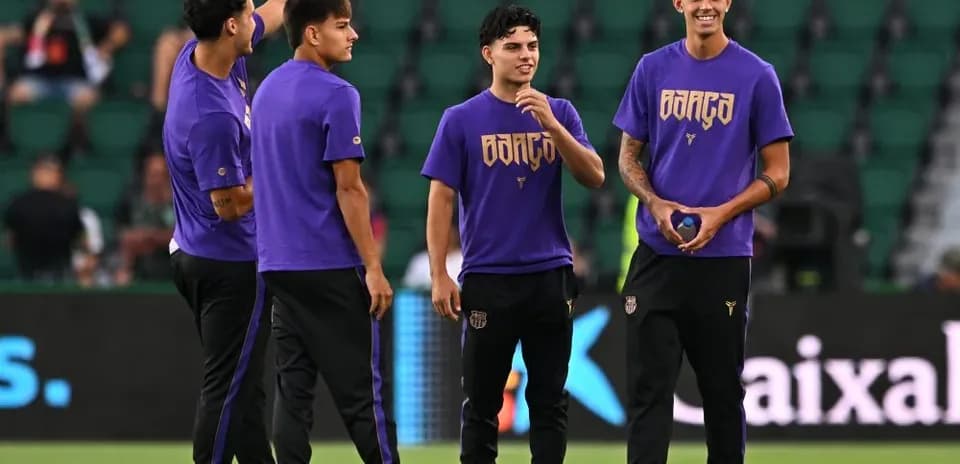 Players warming up in purple jerseys on field