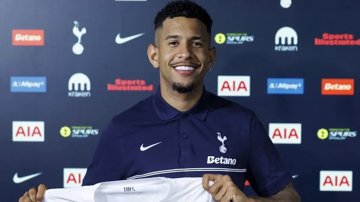 Player holding Tottenham Hotspur jersey at presentation