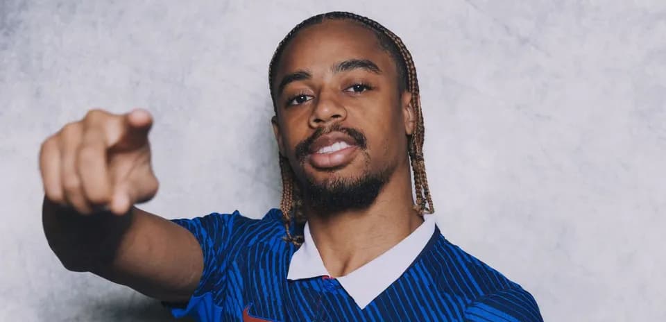 Player in blue jersey pointing at the camera