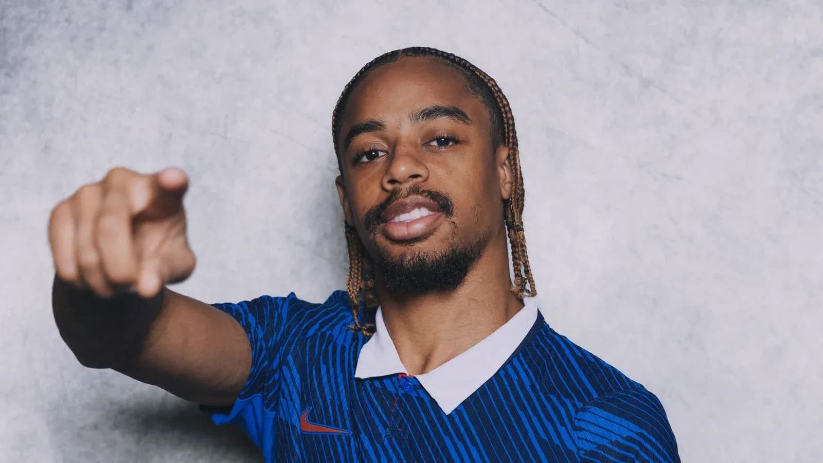Player in blue jersey pointing at the camera