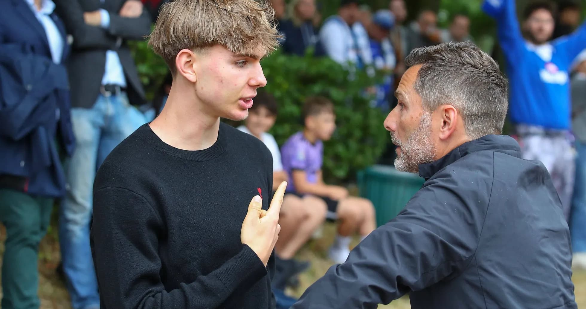 Two men conversing during a sporting event