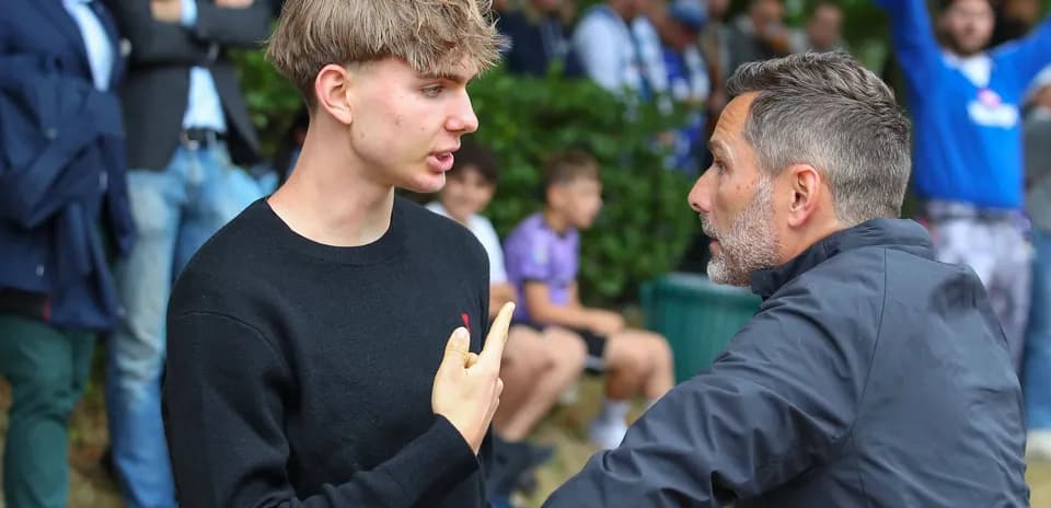 Two men conversing during a sporting event