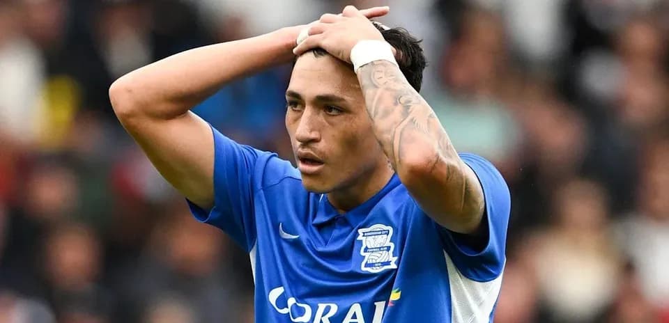 Player in blue shirt holding head during match