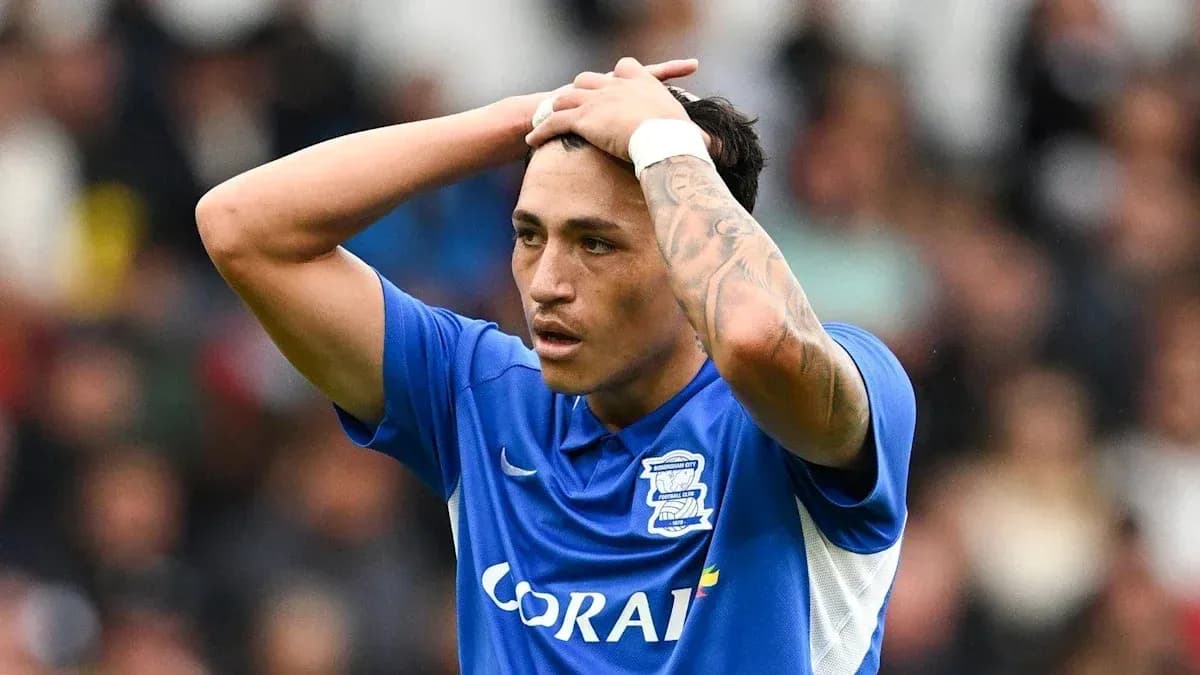 Player in blue shirt holding head during match
