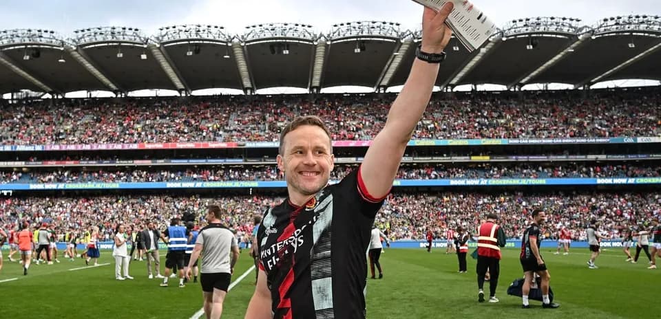 Player celebrating on the pitch with fans in background