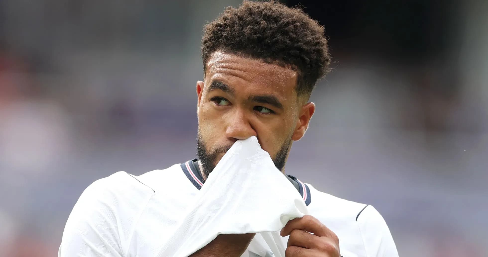 Player holding jersey close to face during match