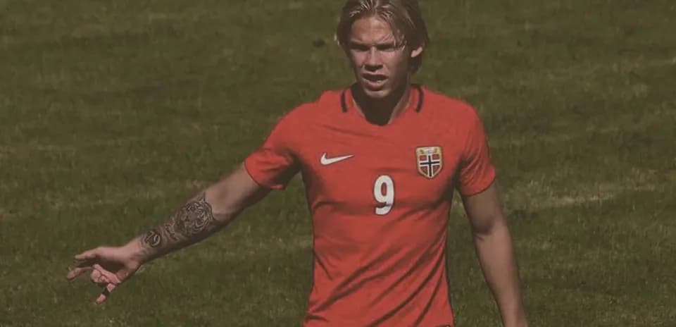 Player in red jersey gesturing on soccer field