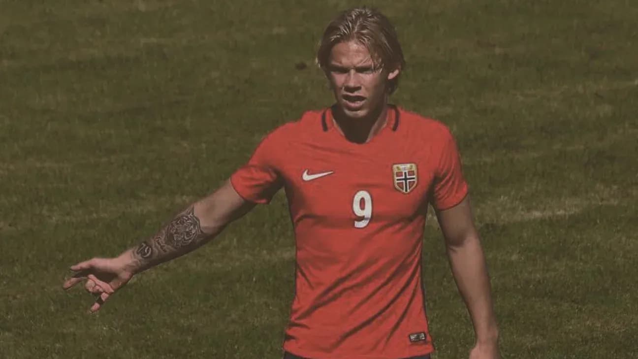 Player in red jersey gesturing on soccer field