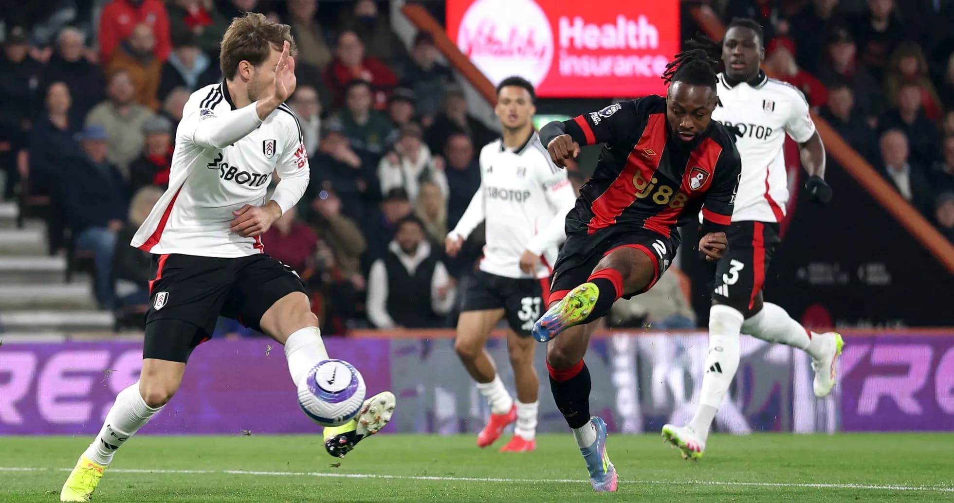 Fulham player challenges Bournemouth opponent during match