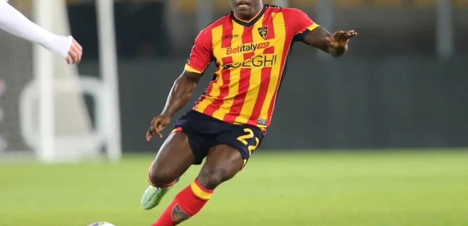 Player in red and yellow kit dribbling the ball