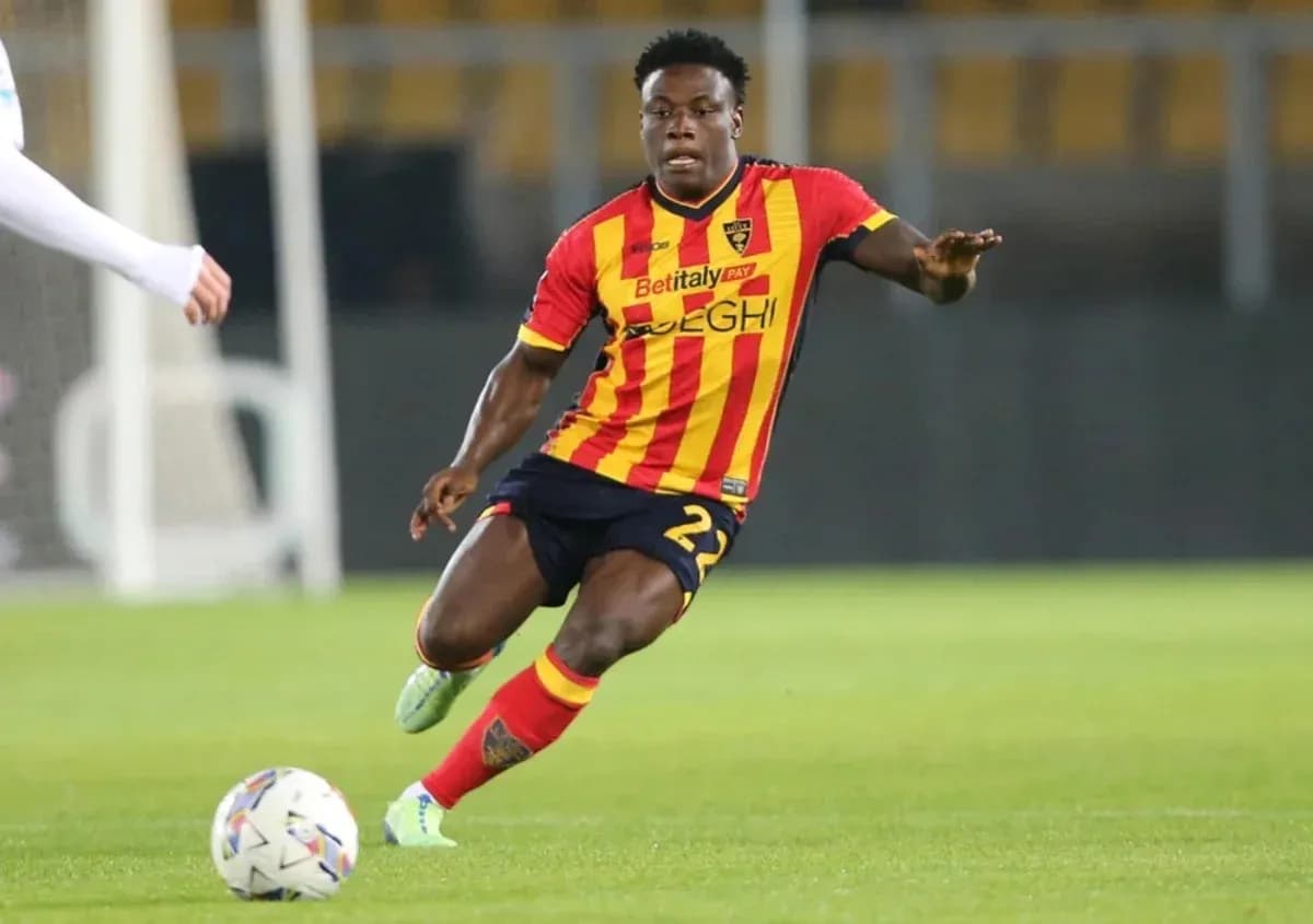 Player in red and yellow kit dribbling the ball