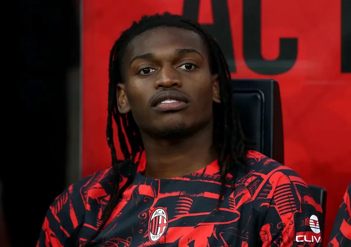 Player seated on bench in AC Milan jersey