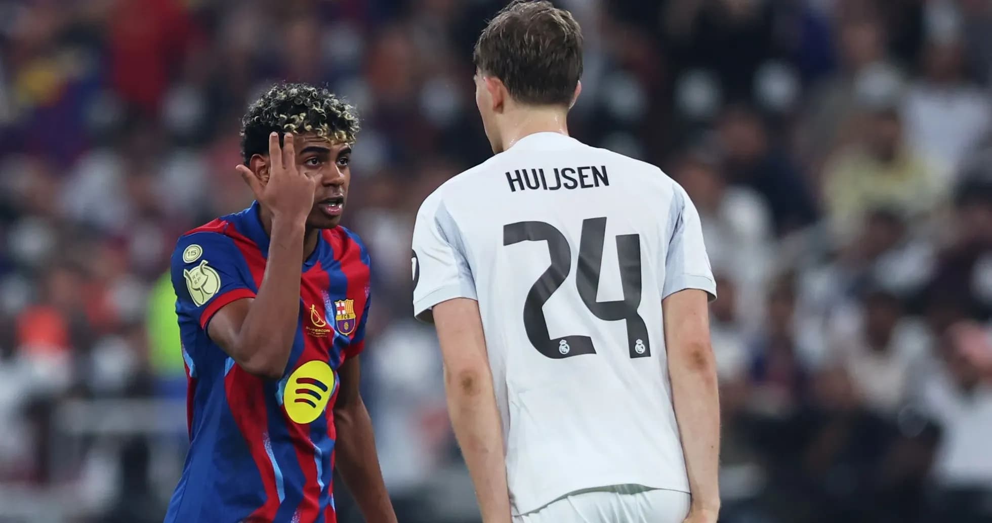 Barcelona player speaking to Real Madrid opponent during match