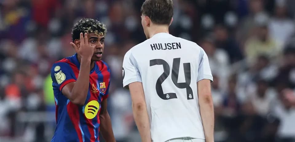 Barcelona player speaking to Real Madrid opponent during match