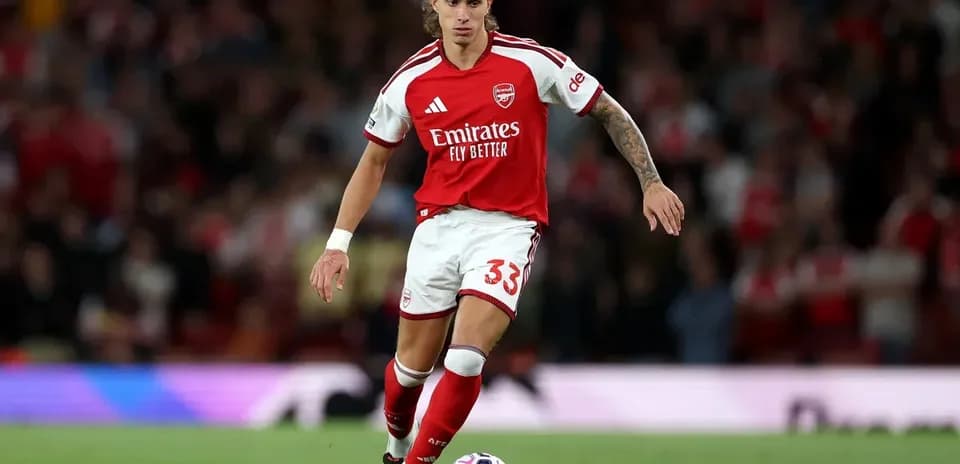 Arsenal player dribbling the ball on the pitch