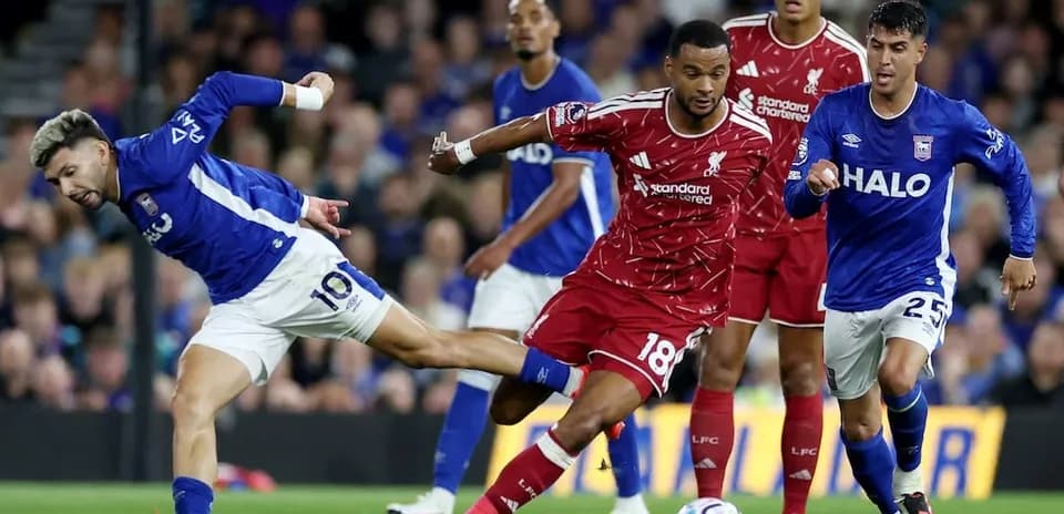 Ipswich player challenges Liverpool defender for the ball