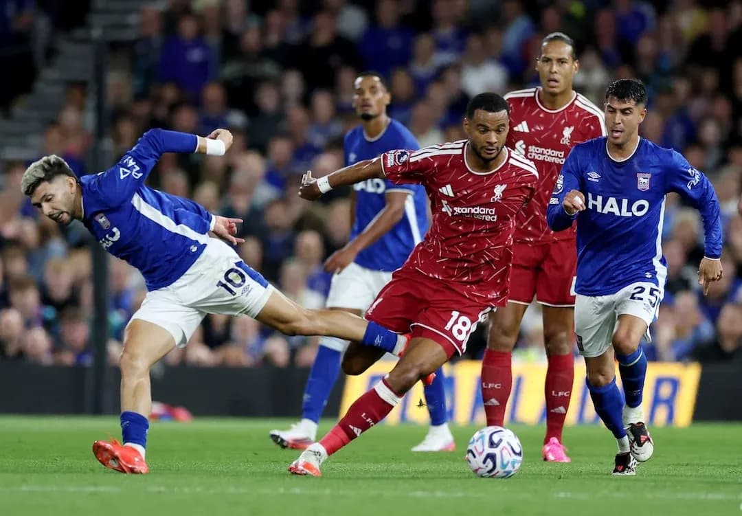 Ipswich player challenges Liverpool defender for the ball