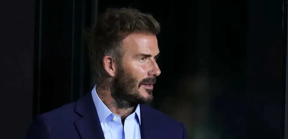 Man in a suit with a beard and tattoos