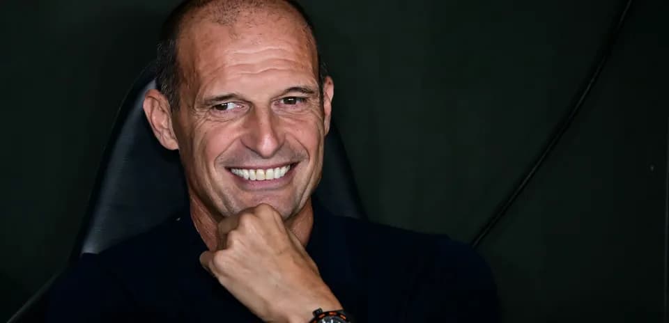 Coach smiling while seated in press conference