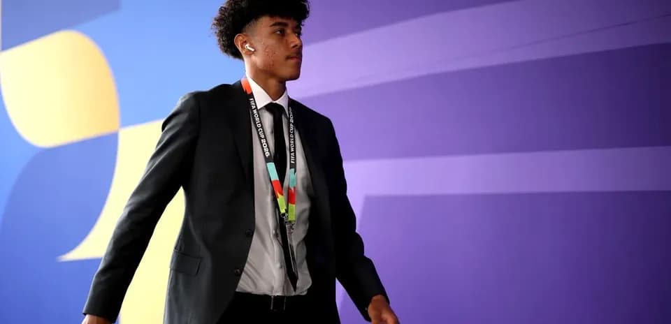 Player walking in formal attire with accreditation