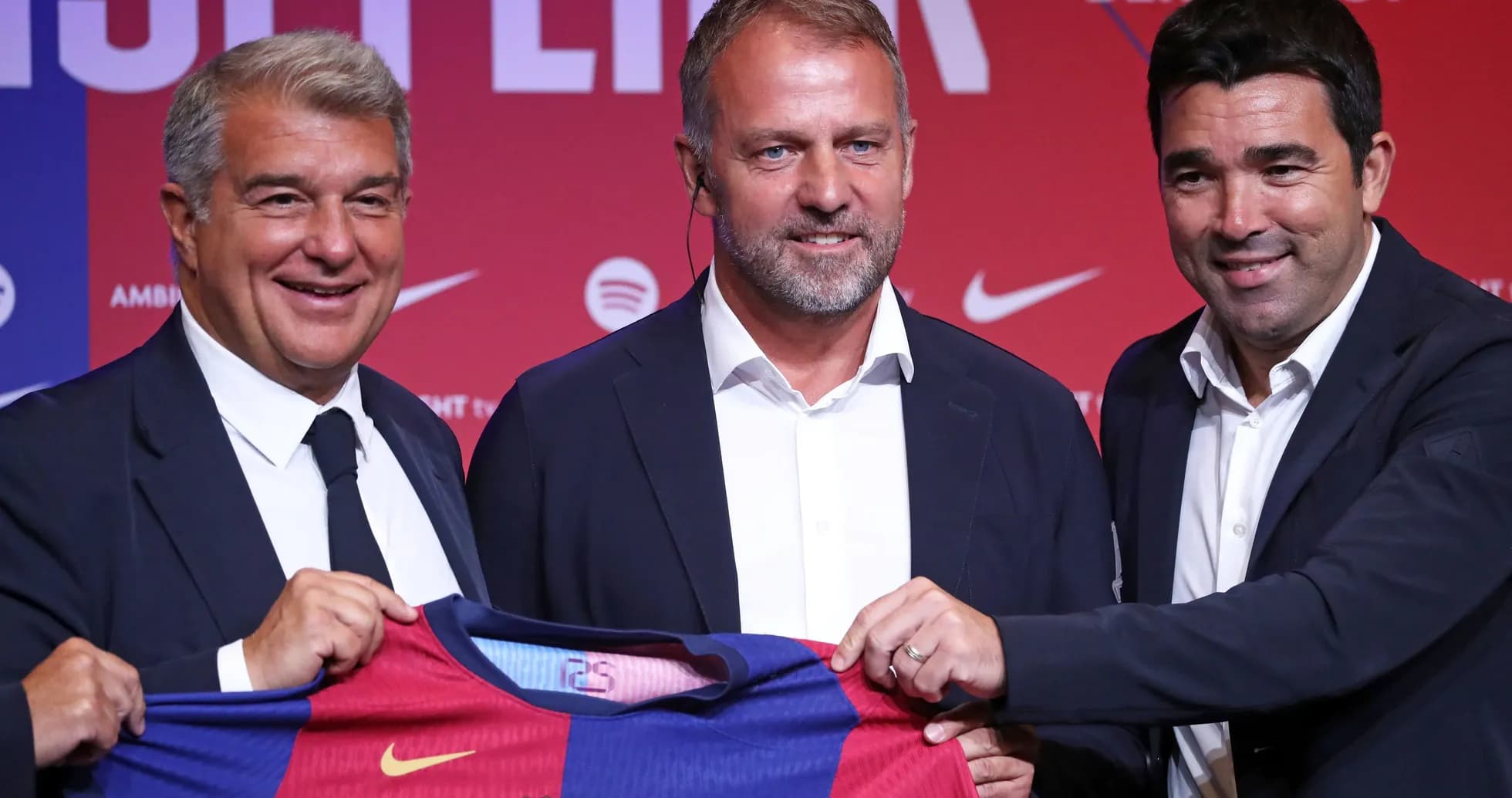 Three officials holding Barcelona jersey at presentation