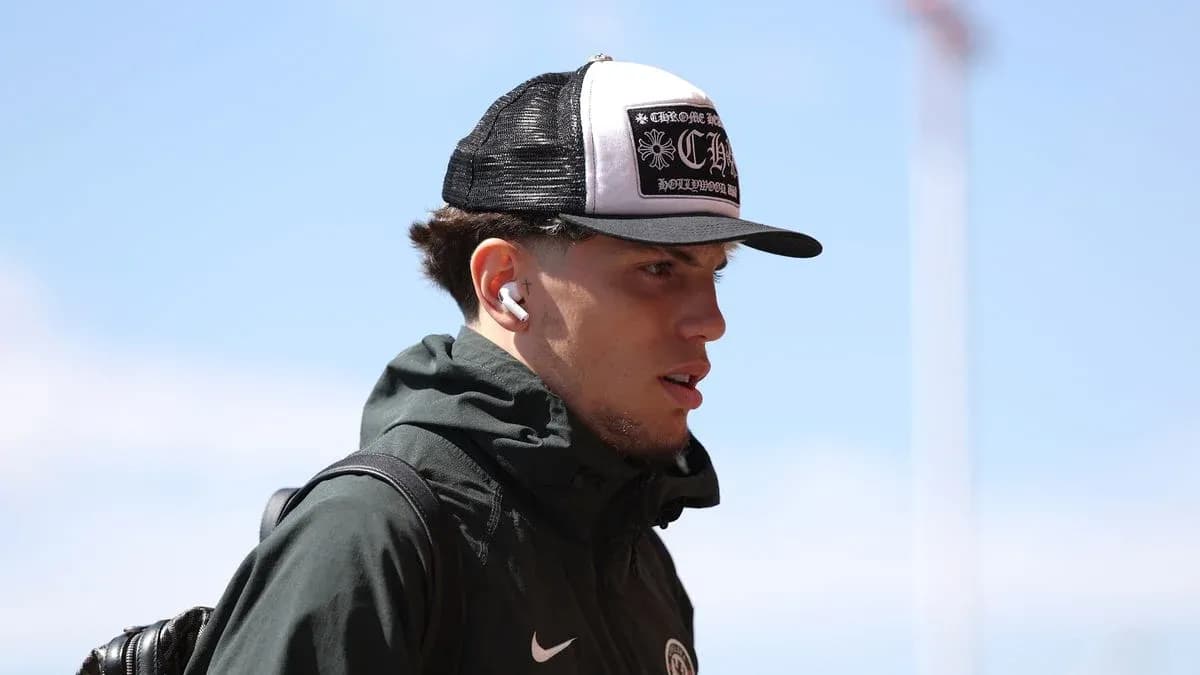 Player wearing a cap and earbuds arriving at venue