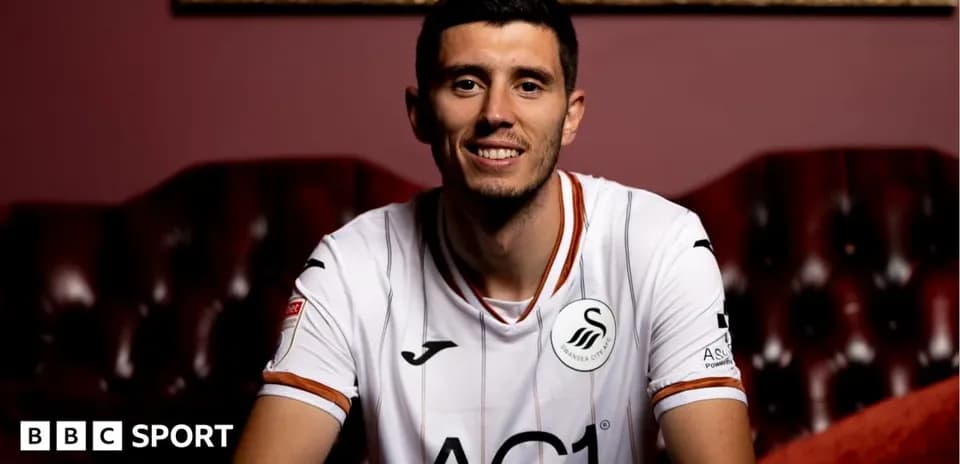 Player posing in Swansea City jersey indoors