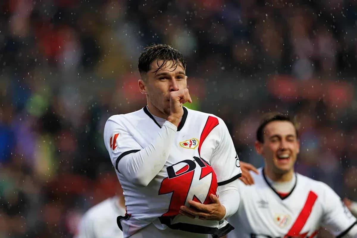 Player celebrating goal with teammates in rain