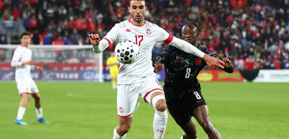 Tunisian player controlling ball while opponent challenges