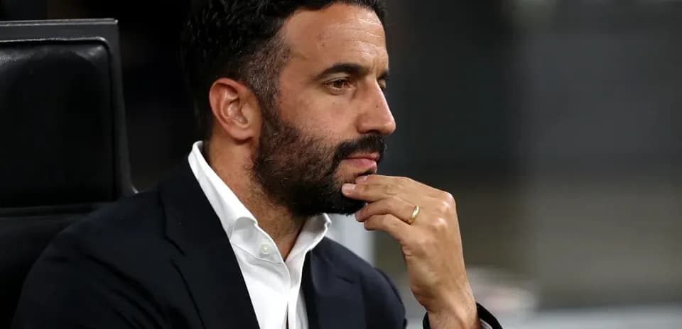 Man in suit with hand on chin during match