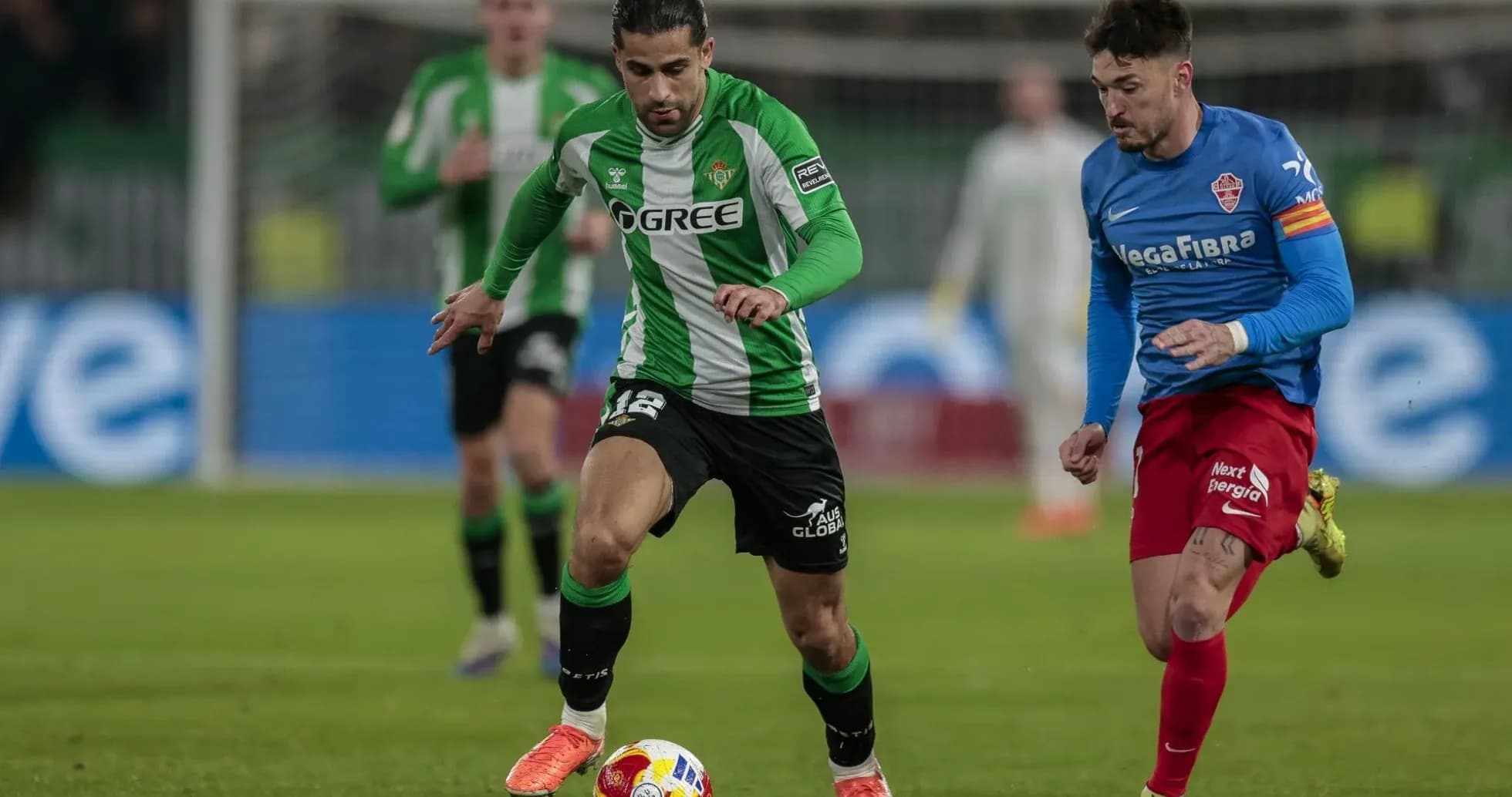 Real Betis player dribbling past Elche defender