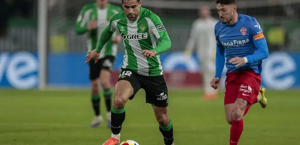 Real Betis player dribbling past Elche defender