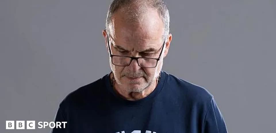 Man wearing glasses looking down, neutral background