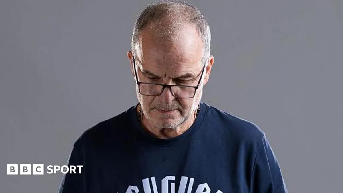Man wearing glasses looking down, neutral background