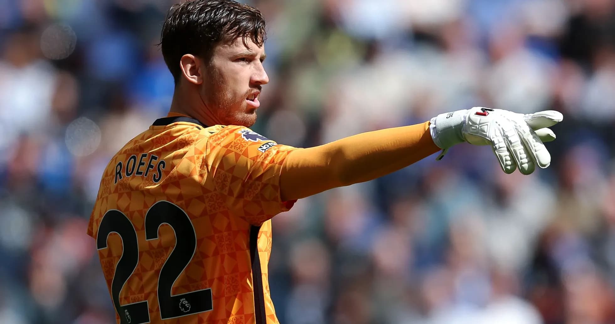 Goalkeeper gesturing during match in orange kit