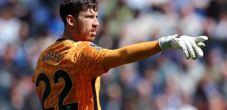 Goalkeeper gesturing during match in orange kit