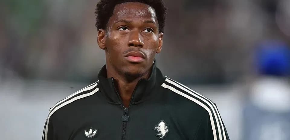 Player in black training jacket before match