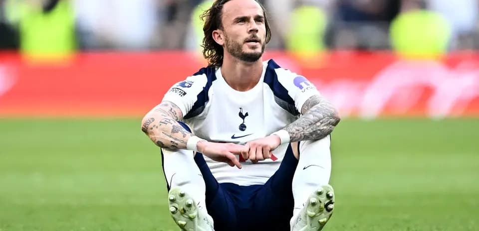 Player sitting on pitch after match with Tottenham kit