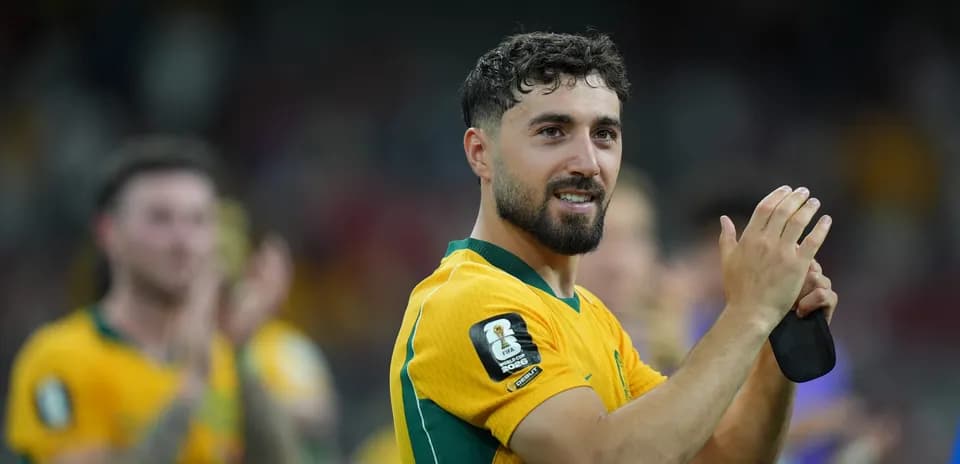 Player in yellow jersey applauding fans after match