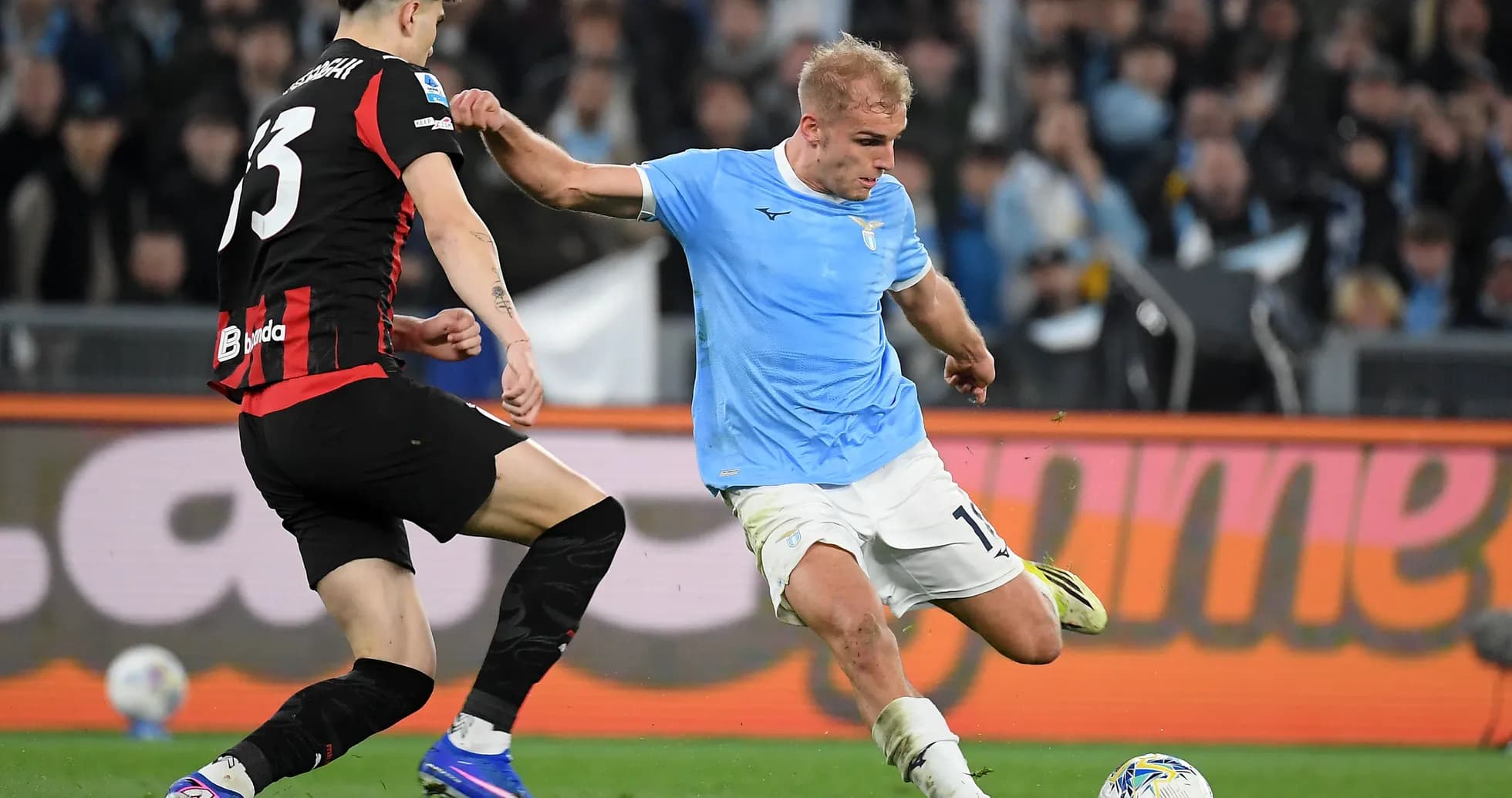Lazio player tackling AC Milan opponent during match