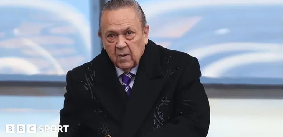 Man in black coat at sporting event venue