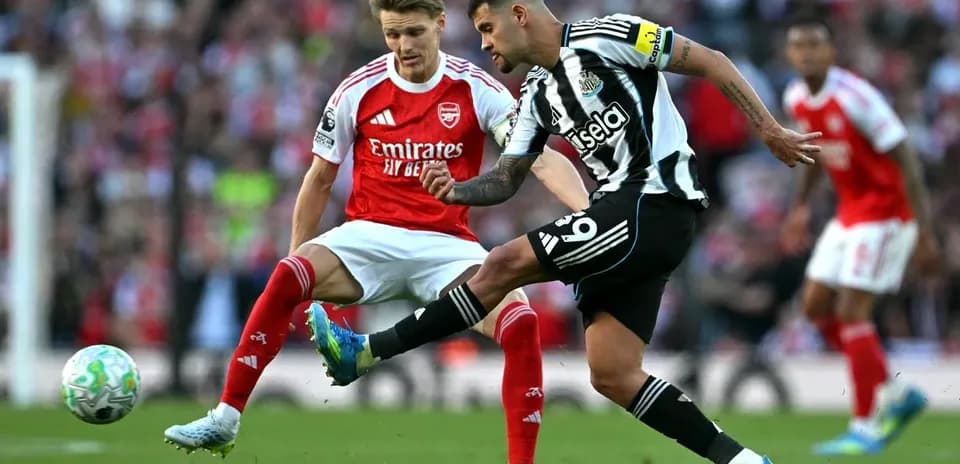 Newcastle player kicking ball against Arsenal player
