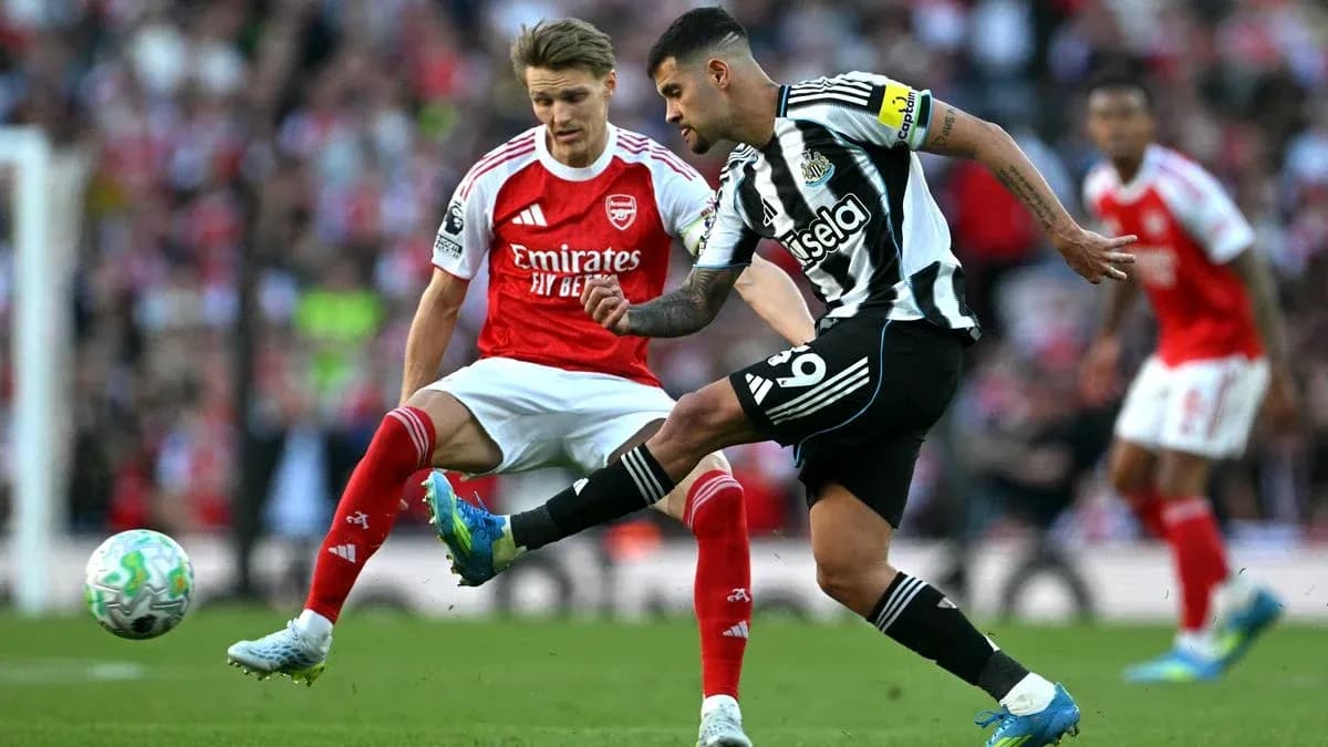 Newcastle player kicking ball against Arsenal player