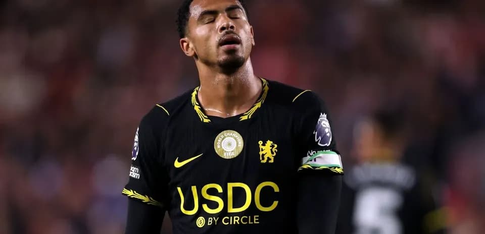 Player in black kit during match with closed eyes