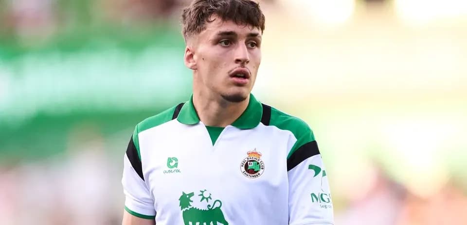 Football player wearing Racing Santander jersey on field