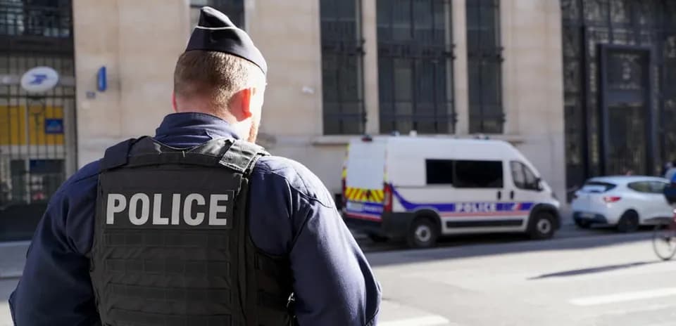 Police officer standing near police van in city