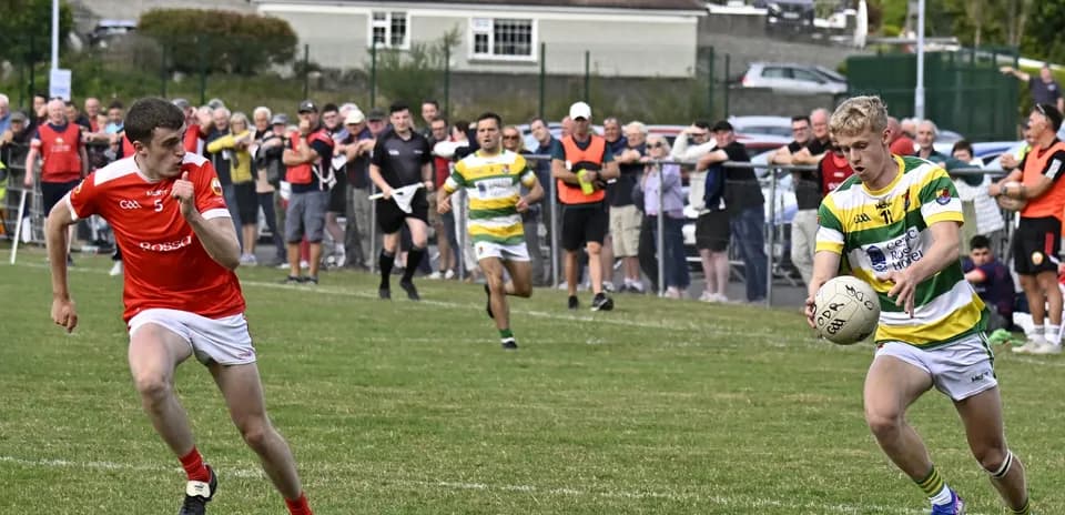Player in green and yellow jersey catching ball during match