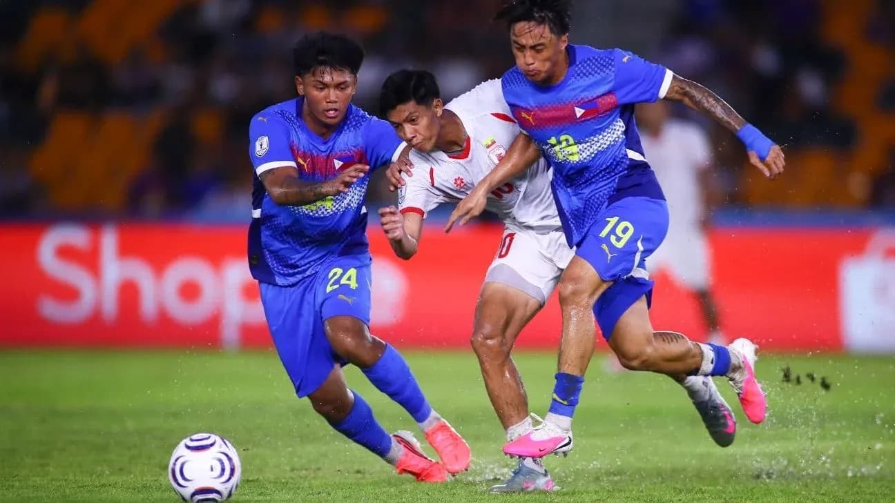 Two players tackling an opponent during football match